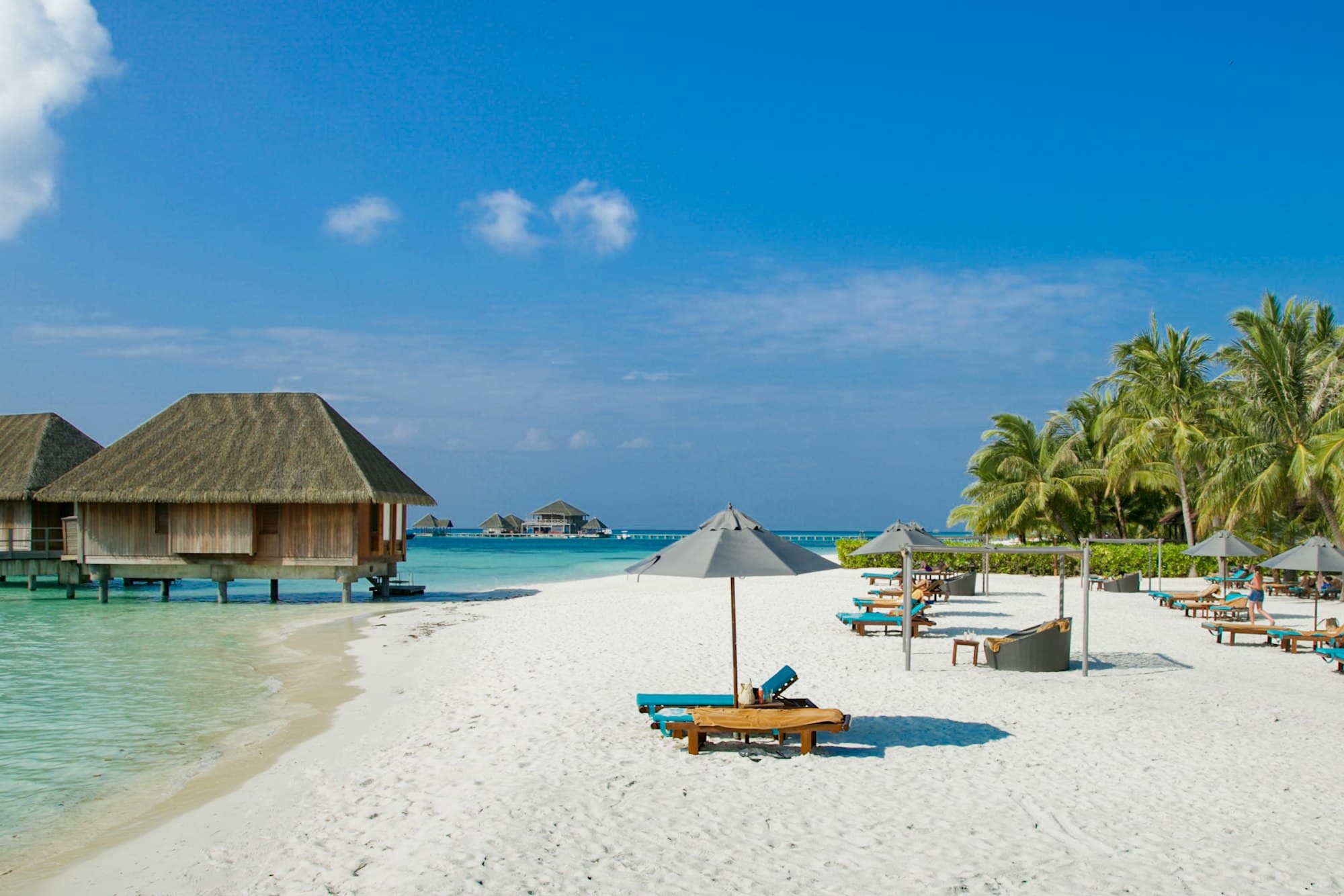 Sun loungers and overwater villas on a resort beach