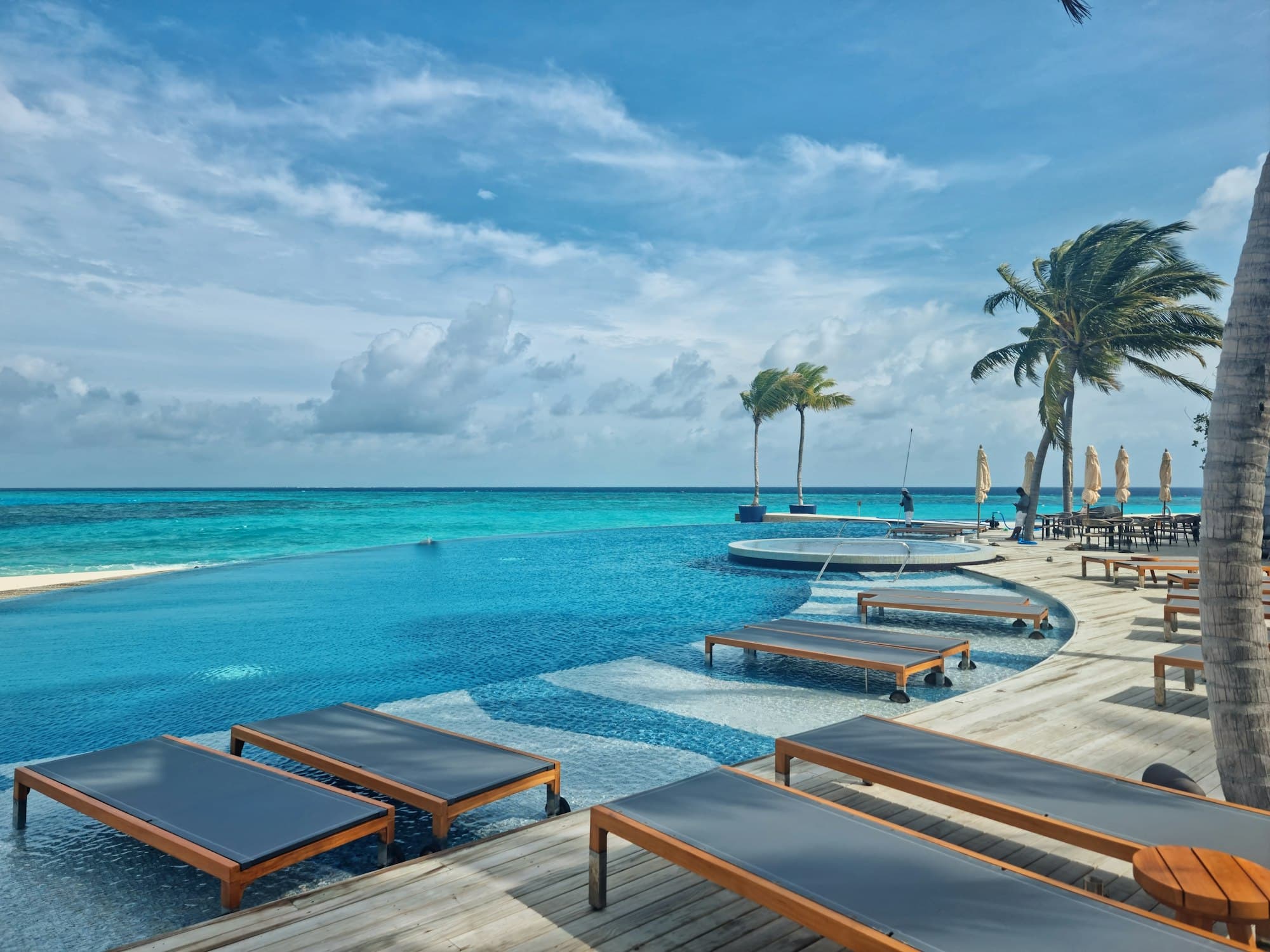 Loungers on a resort deck beside the lagoon
