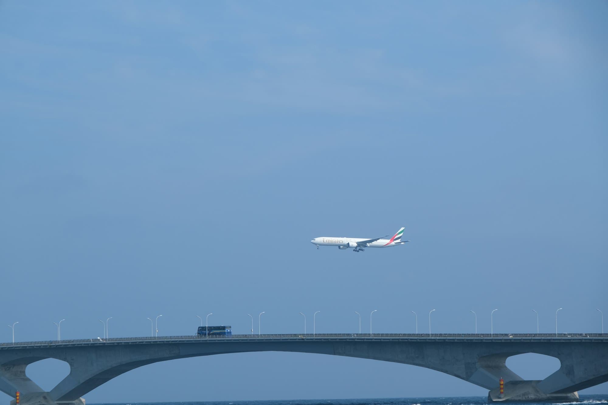 An airliner climbing over the Sinamalé Bridge